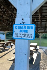 A sign reading clean air zone that forbids smoking and vaping in a public park